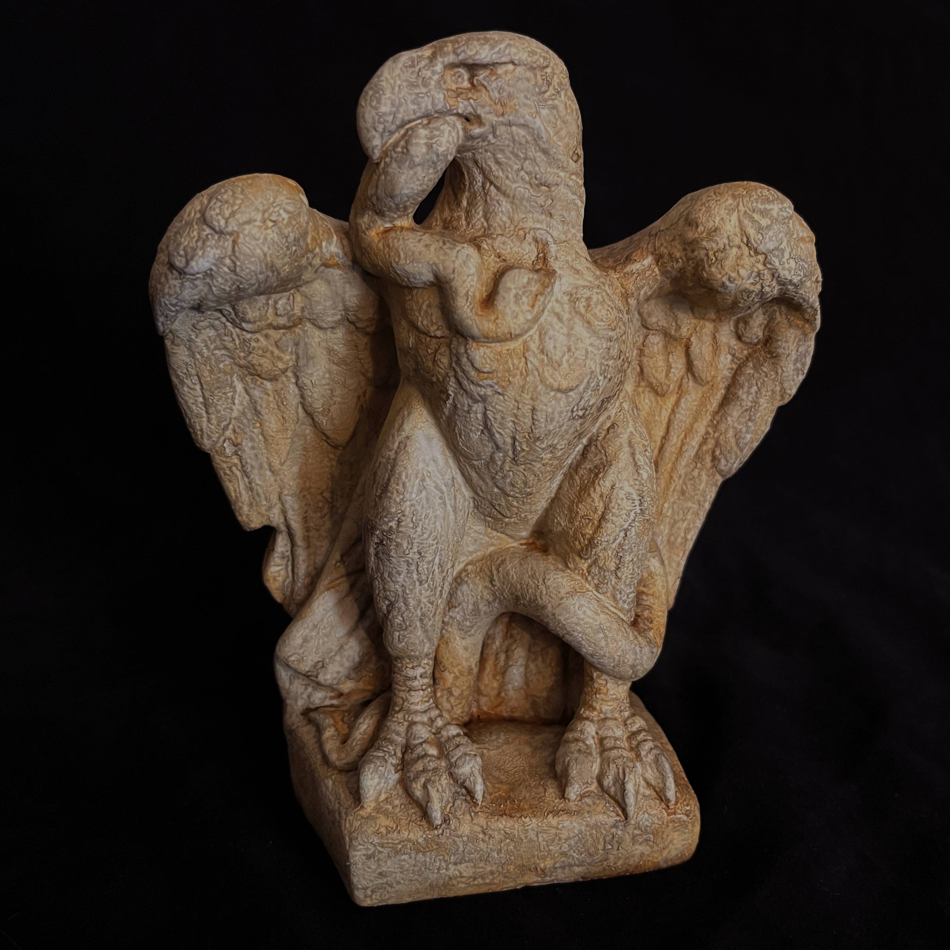 Full front view of a reconstituted limestone replica of a Roman eagle clutching a snake.